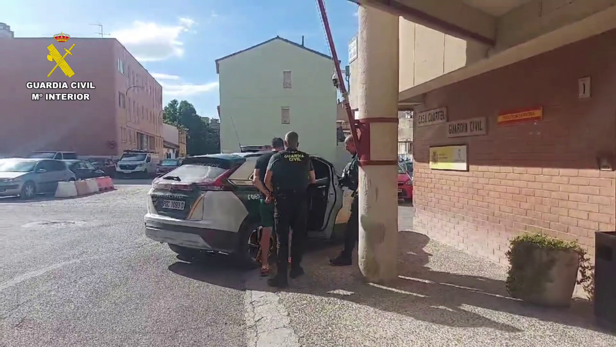 El detenido es conducido a un vehículo de la Guardia Civil.