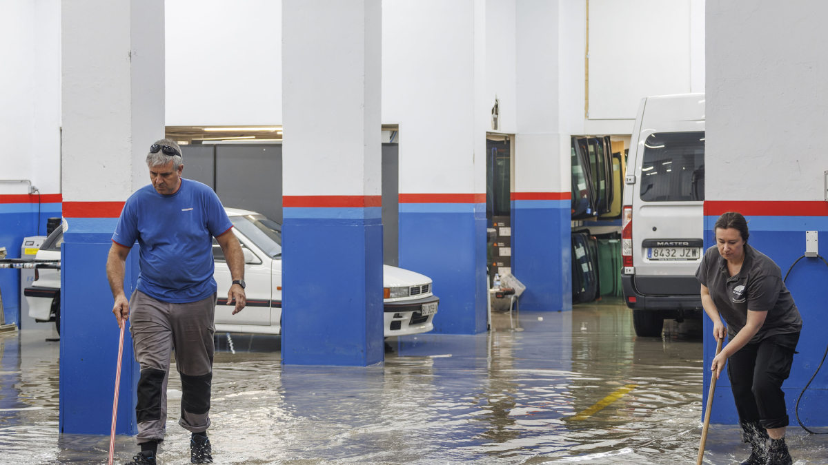 Imagen de empleados de un taller achicando agua.