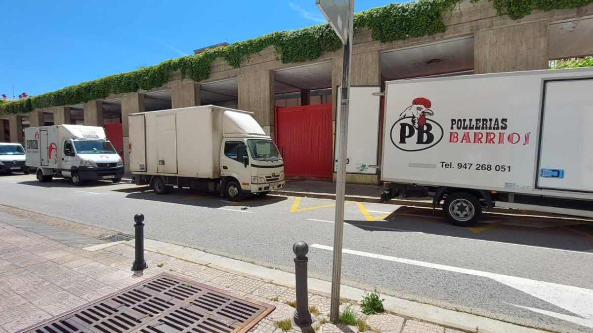 Varios camiones junto al Mercado Norte provisional para descargar género.