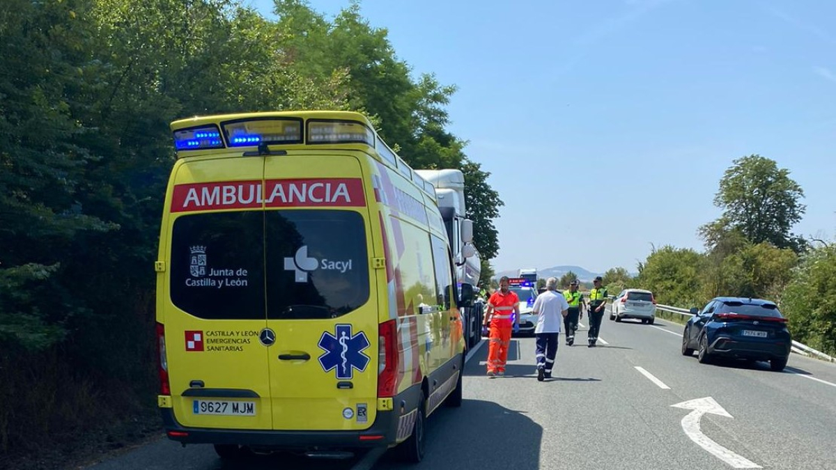 Una ambulancia junto al camión implicado en el accidente y agentes de Tráfico en la carretera N-I.