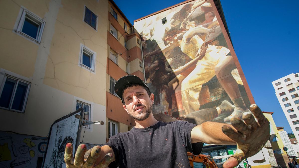 Guido Palmadessa posa justo delante de la nueva obra de arte urbano que se puede visitar en Burgos, en la plaza Hortelanos.