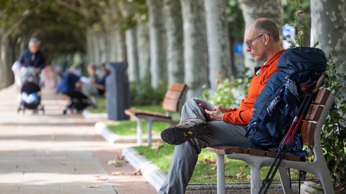 Un turista consulta su teléfono en el Paseo del Espolón.