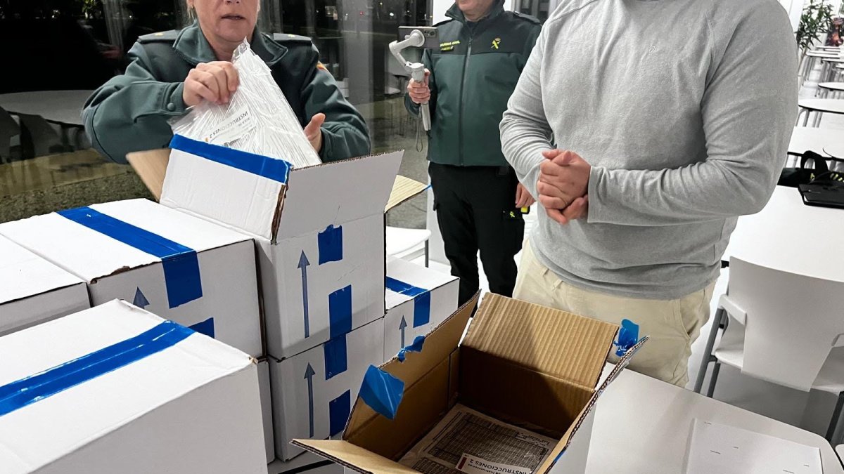 Agentes de la Guardia Civil custodian y comprueban las cajas que contienen las pruebas de oposición para ingresar al Instituto Armado