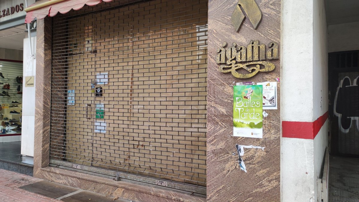 Un cartel anunciando los bailes de tarde en una fachada de un bajo en una calle de Burgos.