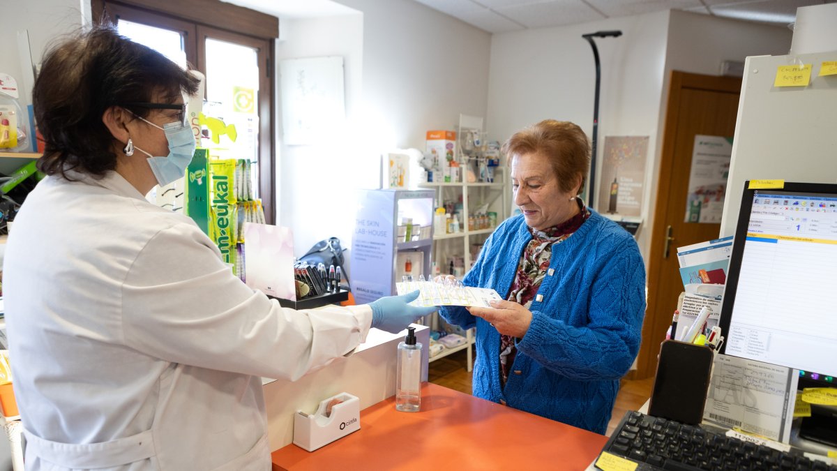 Una usuaria recoge la medicación semanal en la farmacia rural de Valdeavellano de Tera (Soria).
