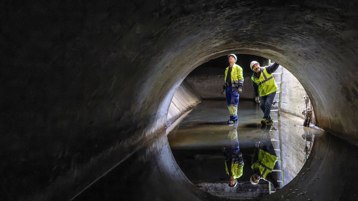 Dos trabajadores de Aguas de Burgos en uno de los puntos de aliviadero de la red, bajo el parque de la Isla y junto al Arlanzón.
