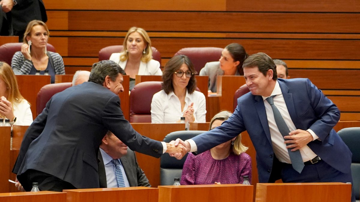 El presidente de la Junta, Alfonso Fernández Mañueco, felicita al consejero de Economía y Hacienda, Carlos Fernández Carriedo, tras finalizar la votación sobre la aprobación del techo de gasto financiero durante la segunda jornada del pleno de las Cortes de Castilla y León.