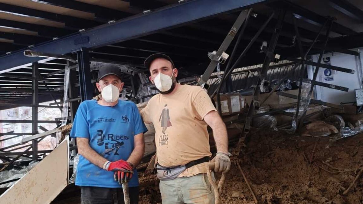Los burgaleses César y Samuel Calvo llevan desde el martes vaciando el barro de una empresa de Chiva en Valencia.