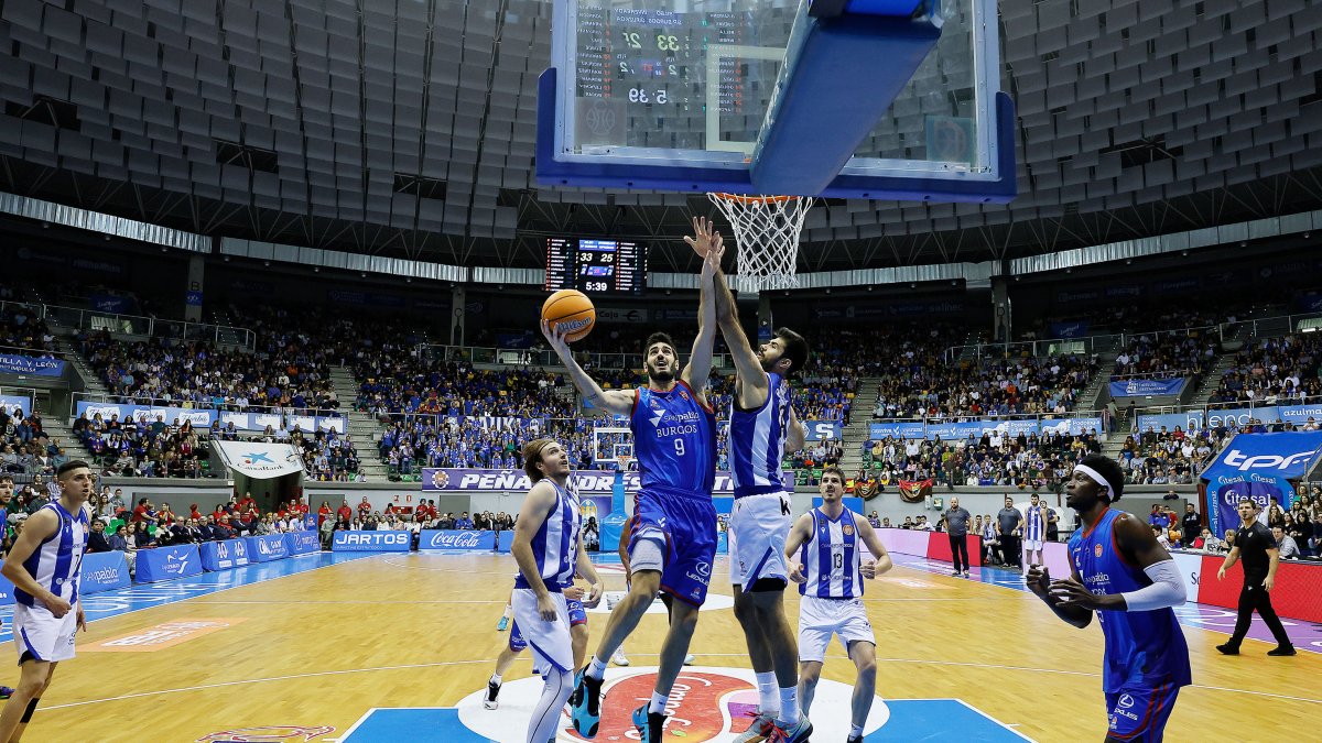 Álex Barrera, a punto de lanzar a canasta rodeado de rivales.