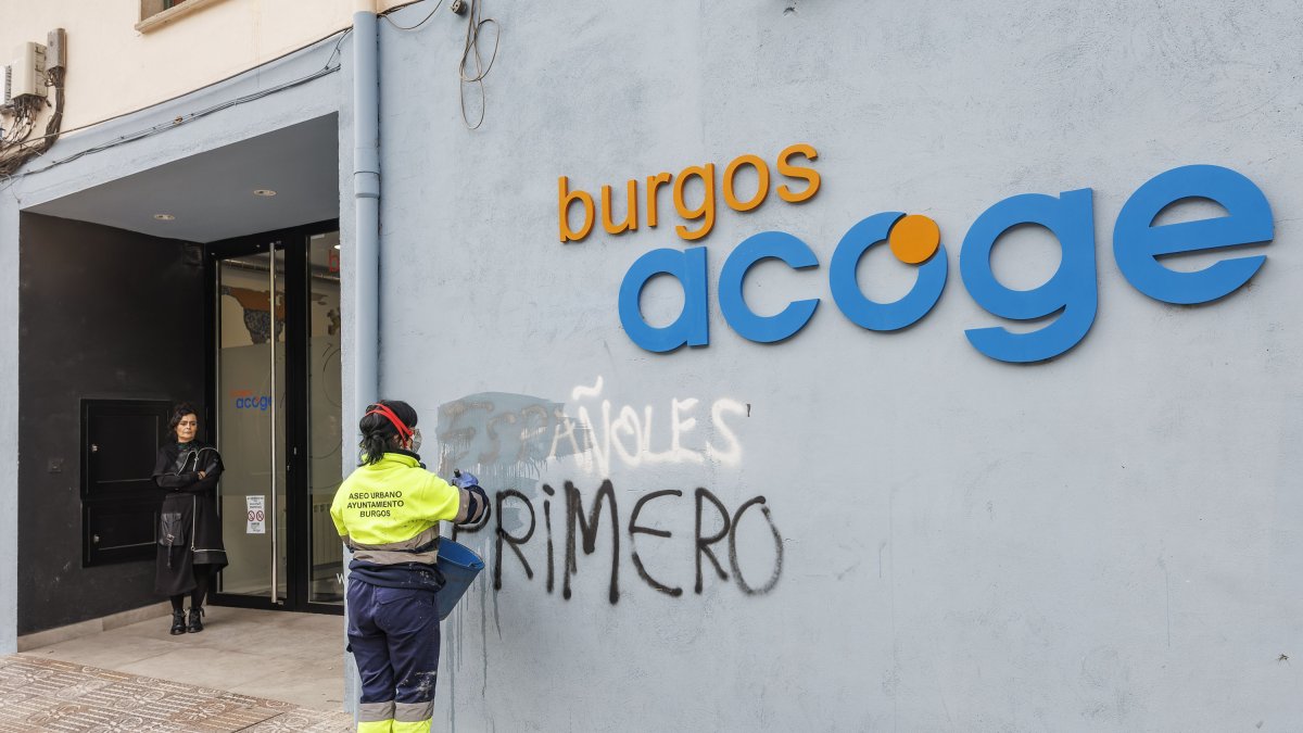 Una operaria de limpieza borra una pintada xenófoba en Burgos Acoge.
