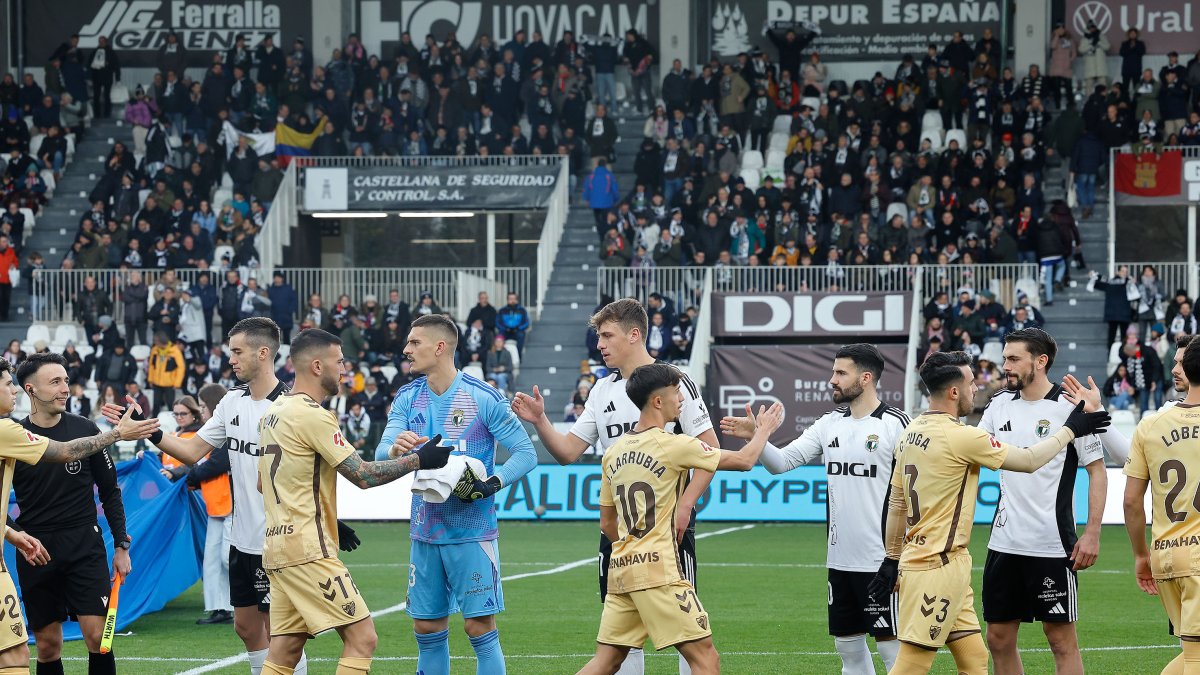 Los jugadores de ambos equipos se saludan antes del comienzo del partido.
