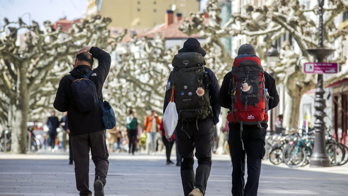Dos peregrinos caminan por el paseo de El Espolón, en la ciudad de Burgos.