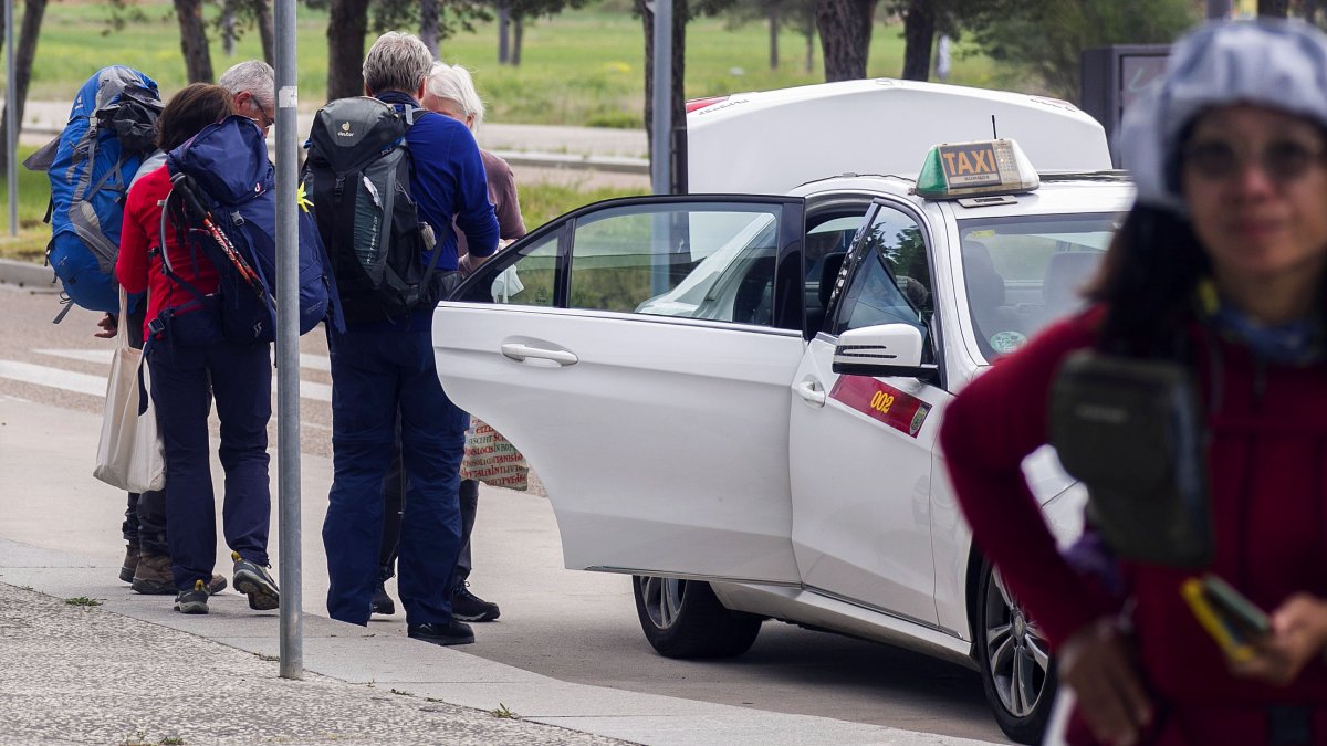 Un grupo de peregrinos coge un taxi en la estación de tren de Burgos.