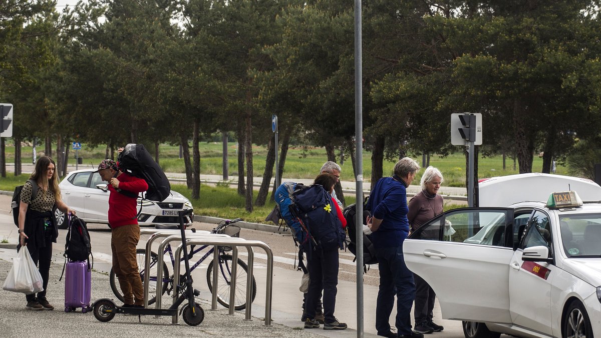 Un grupo de peregrinos coge un taxi en la estación de tren Rosa de Lima Manzano.