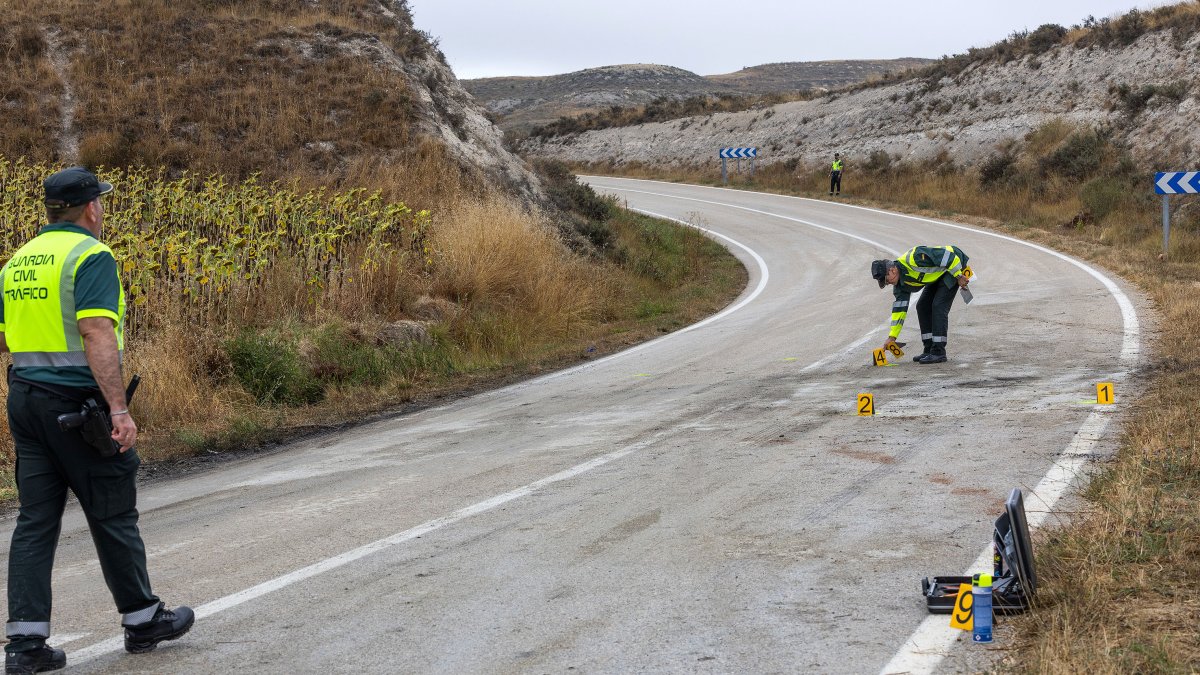 Dos agentes de la Guardia Civil de Tráfico hacen mediciones en el lugar del accidente de la Carretera Poza.