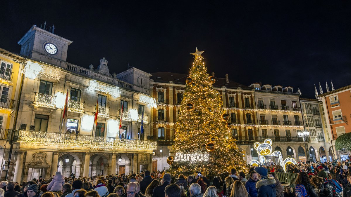 Plaza Mayor iluminada por Navidad y con la fachada del Ayuntamiento en la que se puede leer el rótulo de Felices Fiestas.