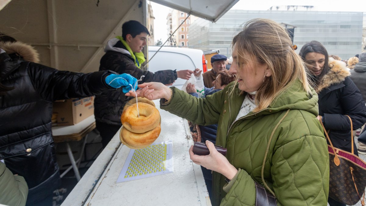 Una mujer compra los tradiciones panecillos de San Lesmes.