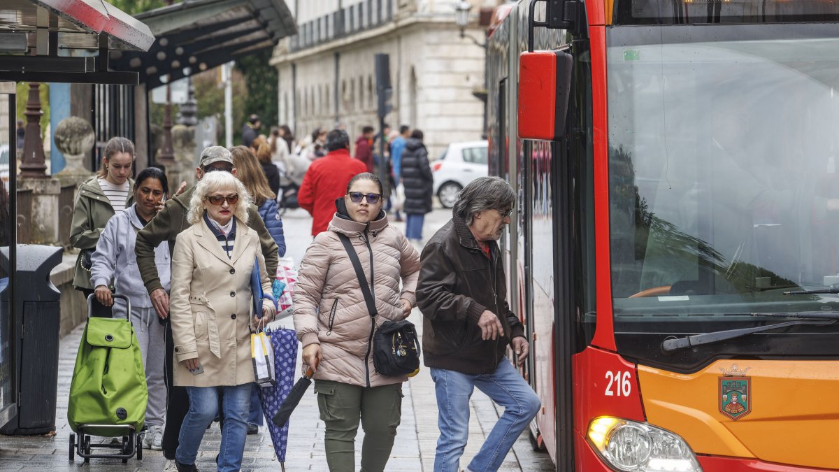 Viajeros suben al autobús, en una parada de la capital burgalesa.
