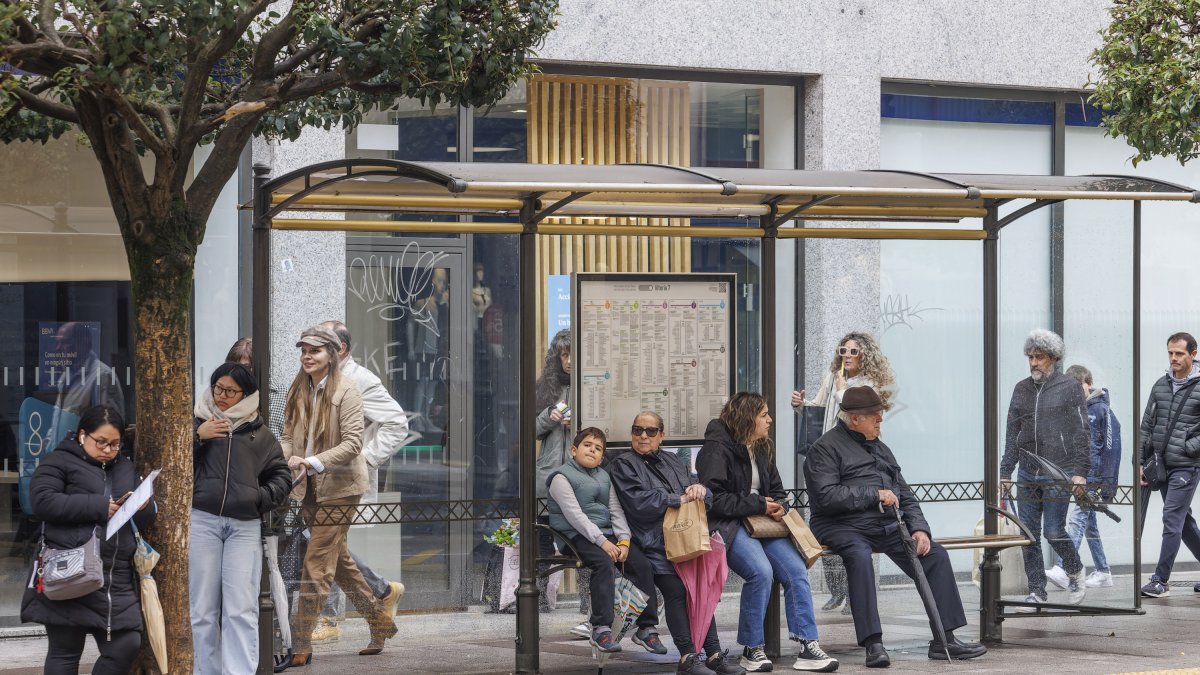 Usuarios del autobús urbano esperan en una parada de la capital burgalesa.