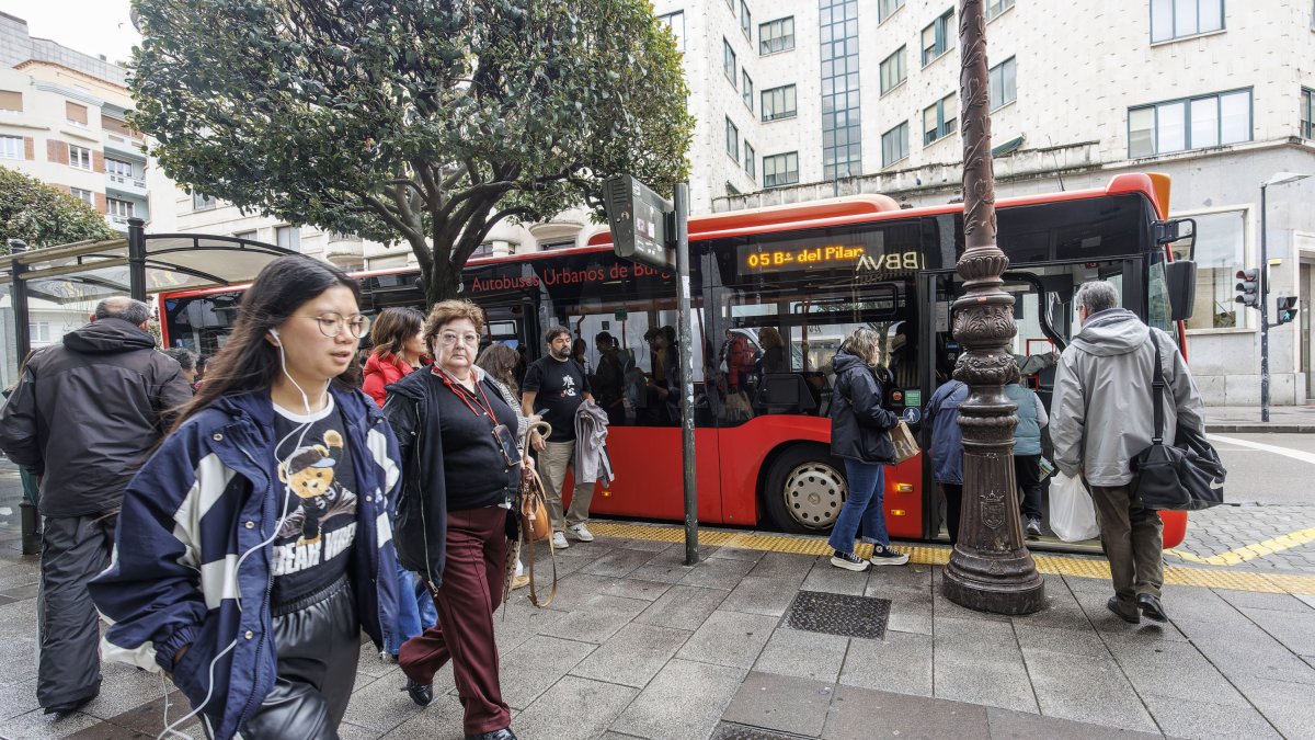 Usuarios del autobús urbano esperan en una parada de la capital burgalesa.