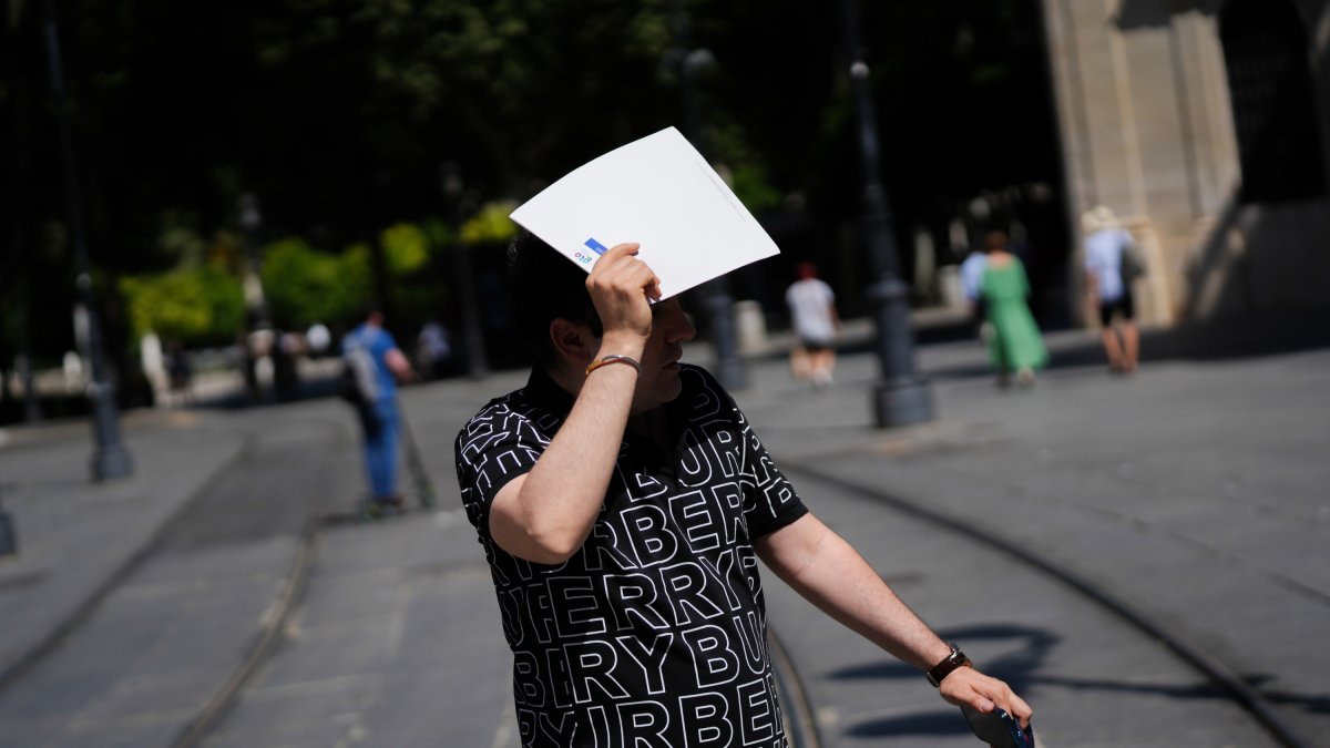 Un hombre se protege del sol con una carpeta. A 28 de mayo de 2025, en Sevilla (Andalucía, España).La Agencia Estatal de Meteorología (Aemet) ha activado para este miércoles el aviso amarillo por calor en diversas zonas de Córdoba, Jaén y Sevilla, donde l.