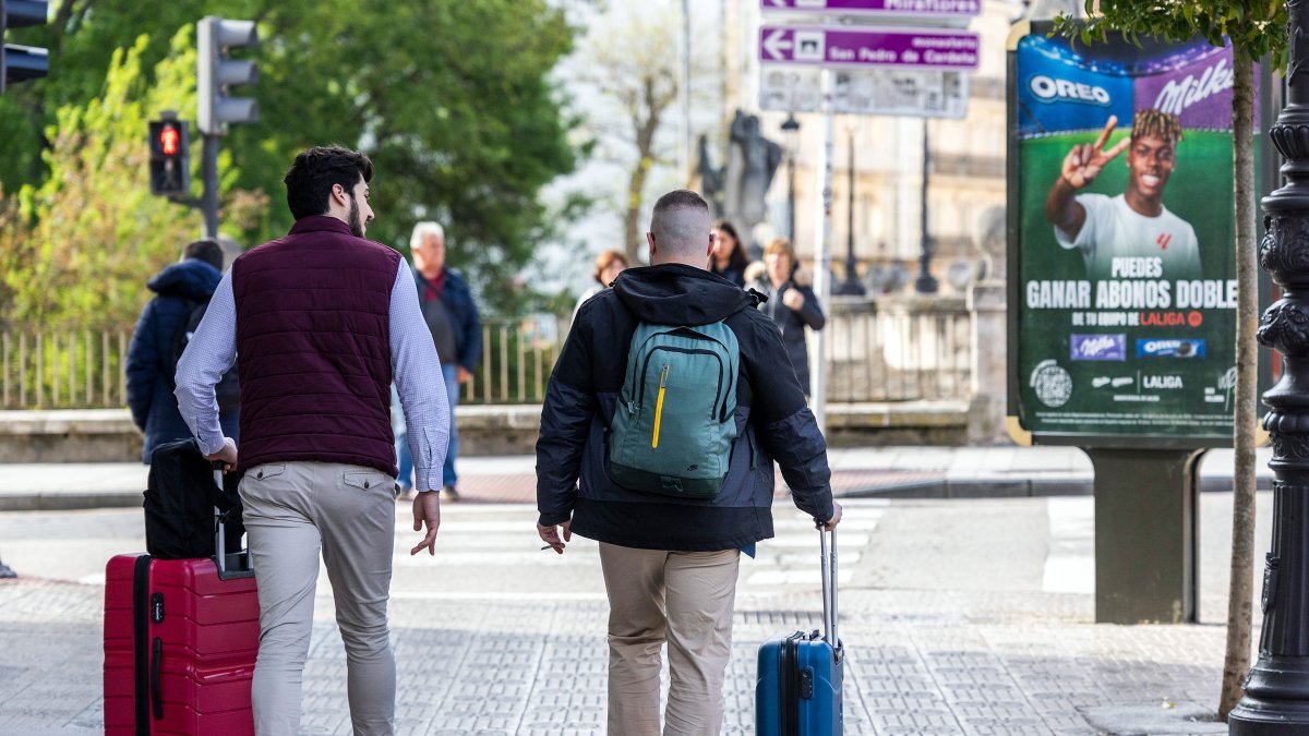 Dos hombres con maletas por el centro de la ciudad de Burgos.