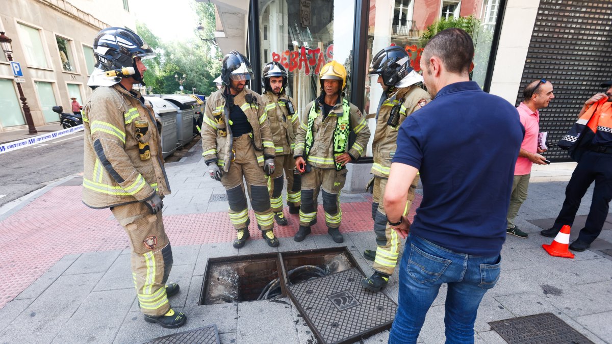 Bomberos de Burgos junto a una arqueta en la calle Vitoria.