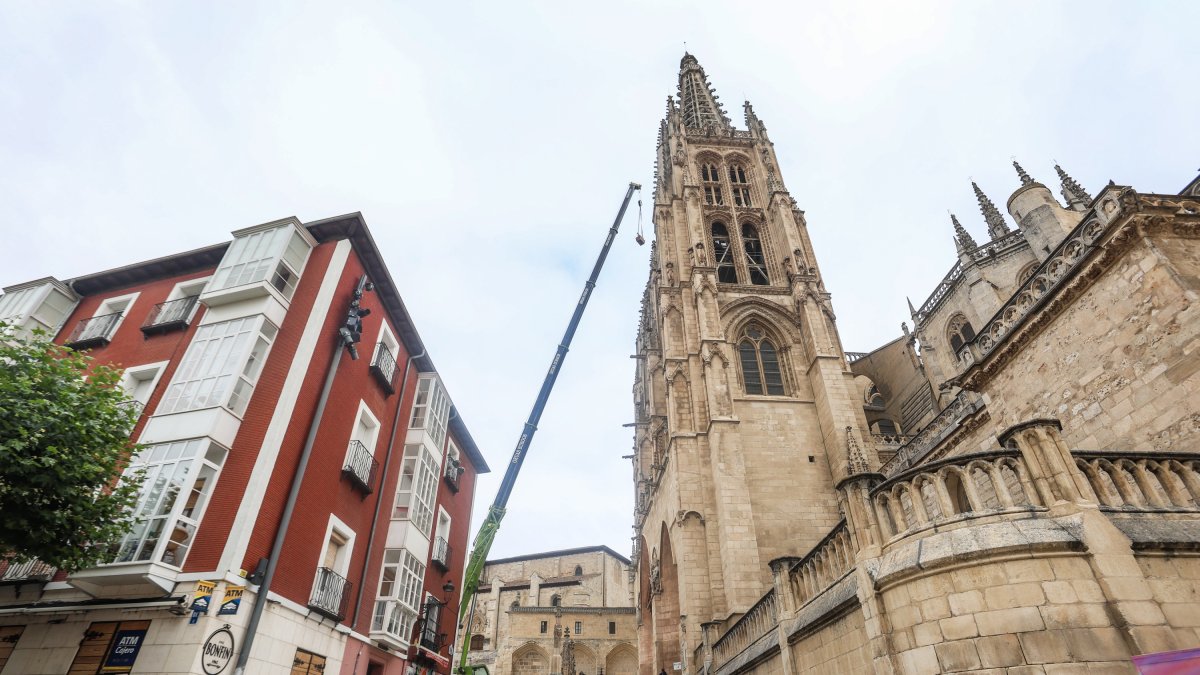 La grúa instalada en la plaza de Santa María traslada el yugo del campanario tras su arreglo.