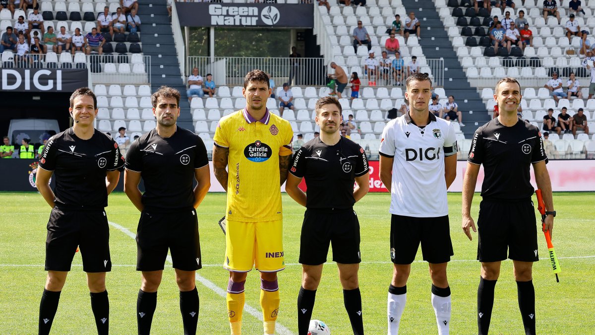 Imagen de los capitanes y el equipo arbitral.