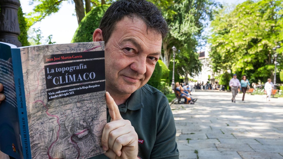 Juanjo Martín, en el paseo del Espolón, con un ejemplar de 'La topografía de Clímaco'.