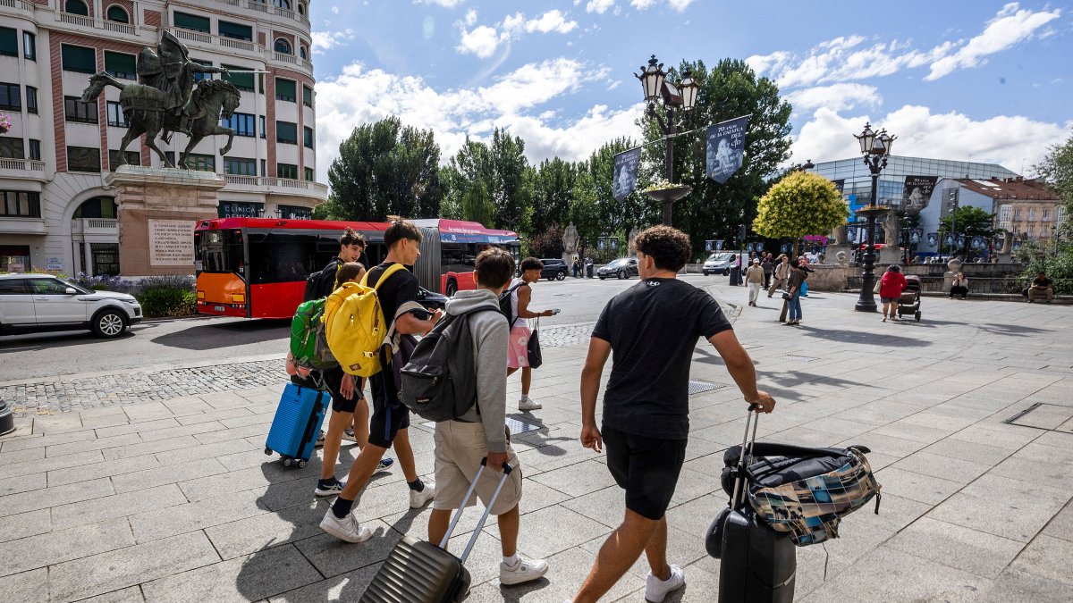 Un grupo de jóvenes caminan con sus maletas por el centro de Burgos.