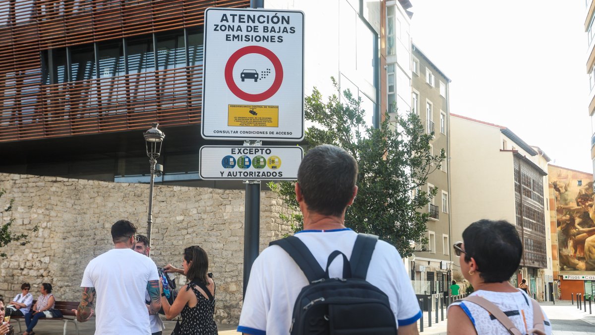 Varias personas junto a una de las señales de entrada a la ZBE de Burgos.