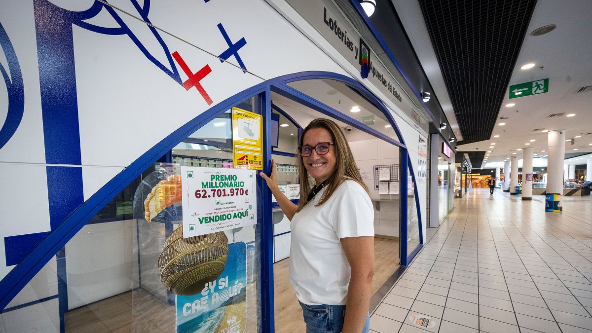 Delia, dependienta de la administración del El Mirador posan con el cartel del premio.