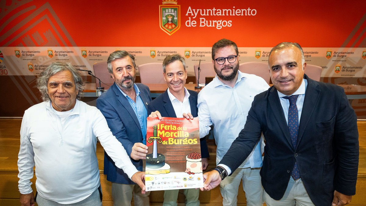 Representantes de las entidades responsables de la I Feria de la Morcilla de Burgos IGP posan junto al cartel del evento.