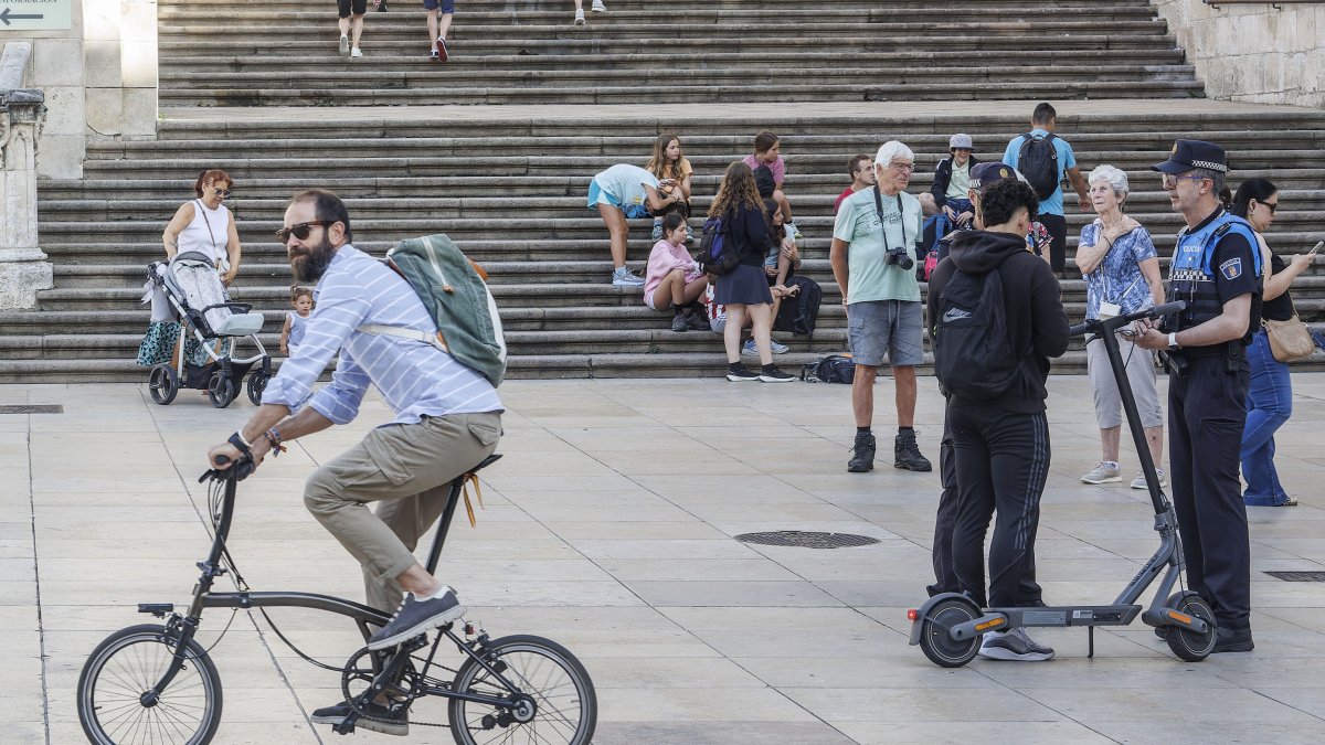 Agentes de la Policía Local paran a un joven en patinete eléctrico en la Plaza del Rey San Fernando.