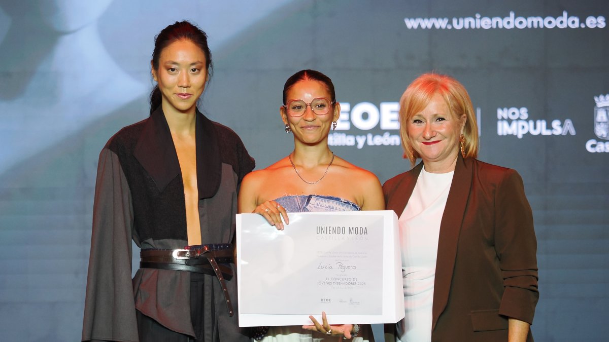 En el centro, la ganadora del Concurso de Jóvenes Diseñadores 2025, Lucía Peguero; a la derecha, la consejera de Industria, Comercio y Empleo de la Junta de Castilla y León, Leticia García; posan junto a la modelo que lleva la propuesta ganadora, 'Meiga.