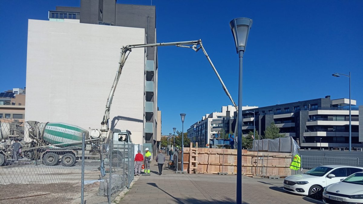 Los peatones caminan por debajo de la maquinaria de obra en la calle Siervas de Jesús.