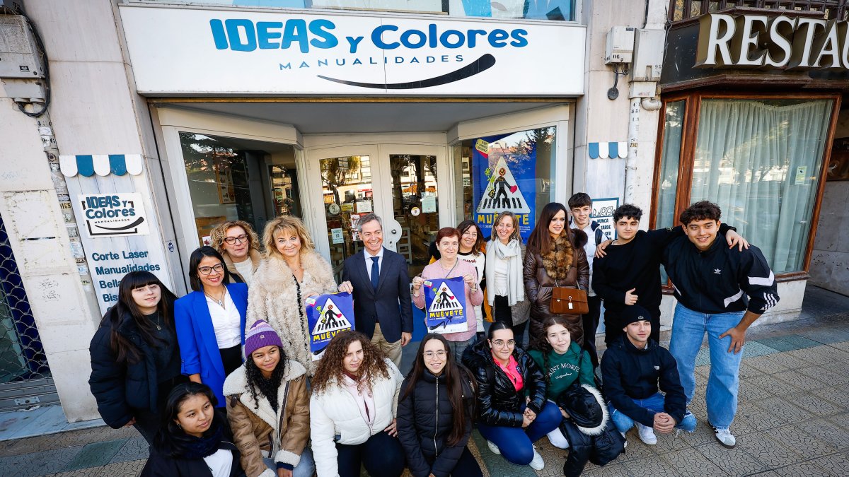 Algunos de los alumnos participantes y responsables de la iniciativa posan frente a uno de los comercios participantes.