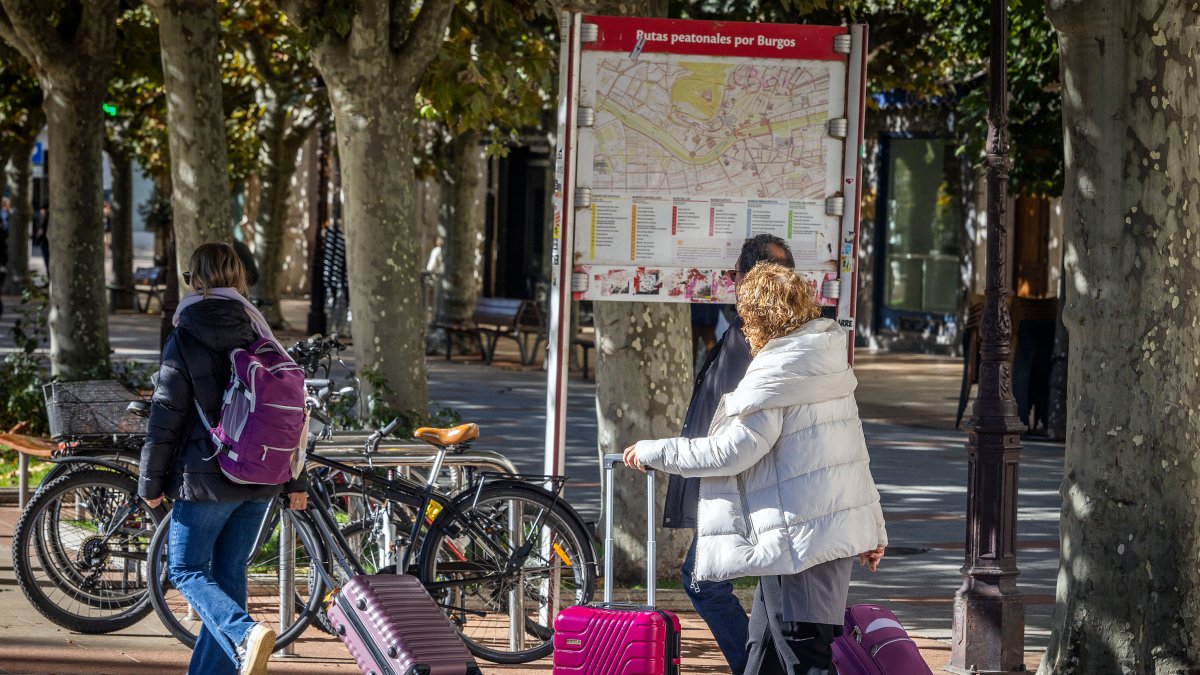 Personas con maletas pasean por las calles de Burgos, en un fin de semana reciente.