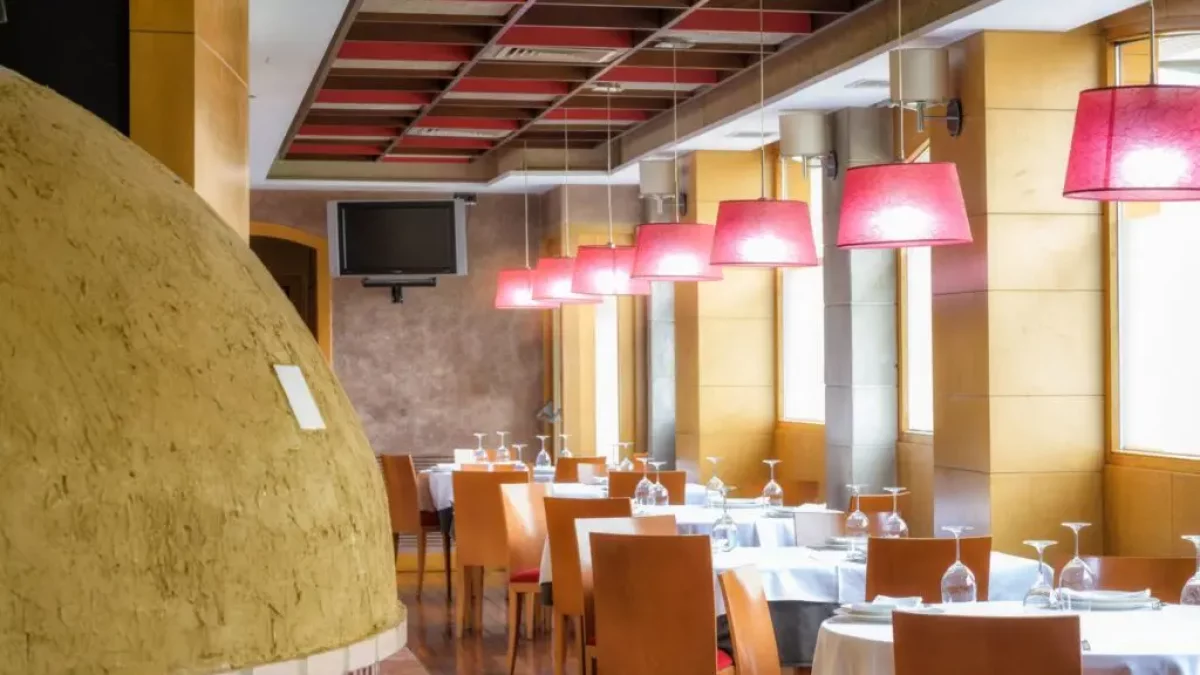 Vista del horno y el comedor del Asador San Lorenzo, restaurante tradicional especializado en lechazo asado en horno de leña, cocina castellana y producto de proximidad.