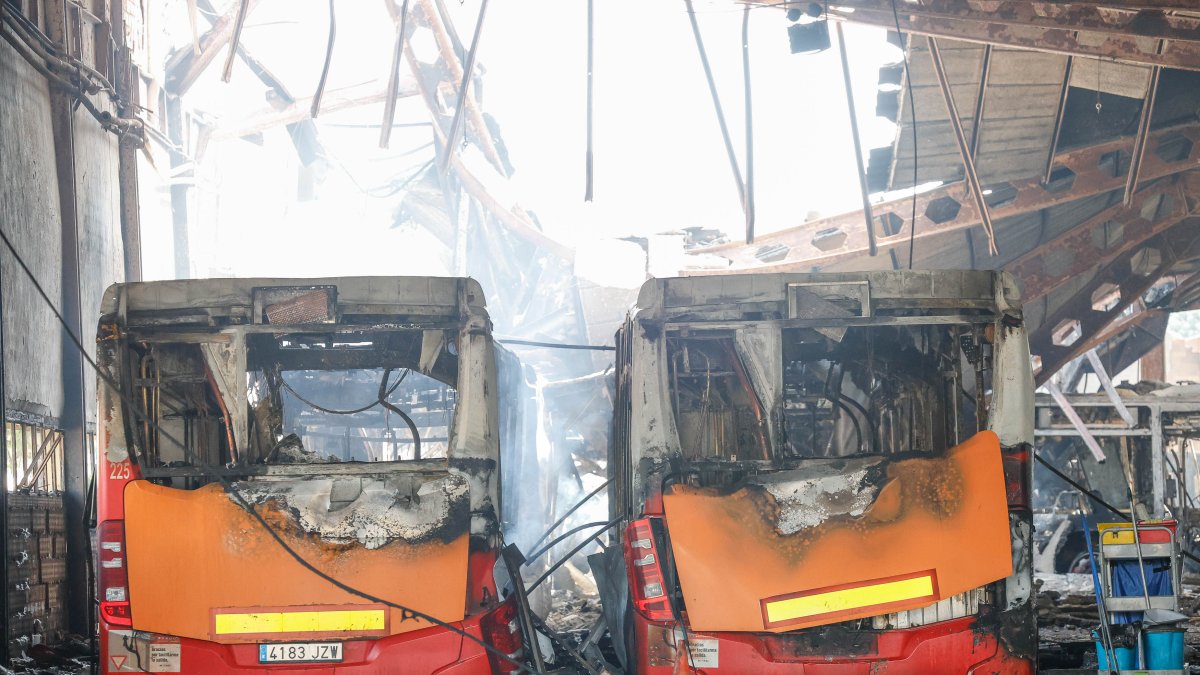Imagen de dos autobuses quemados.