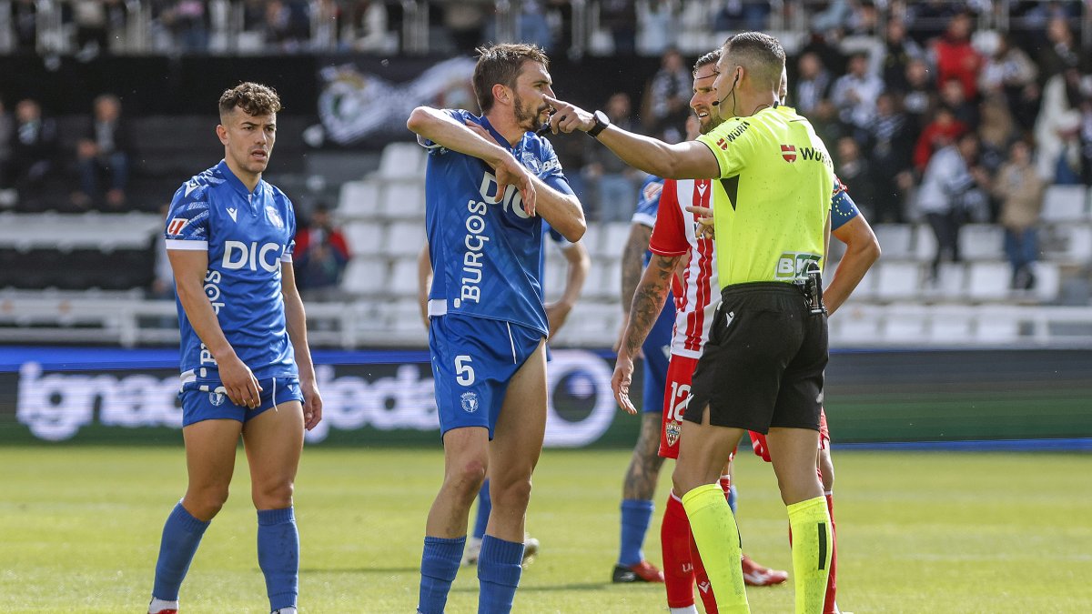 El colegiado Salvador Lax da explicaciones al capitán del Burgos CF, Atienza, durante el encuentro ante la UD Almería.