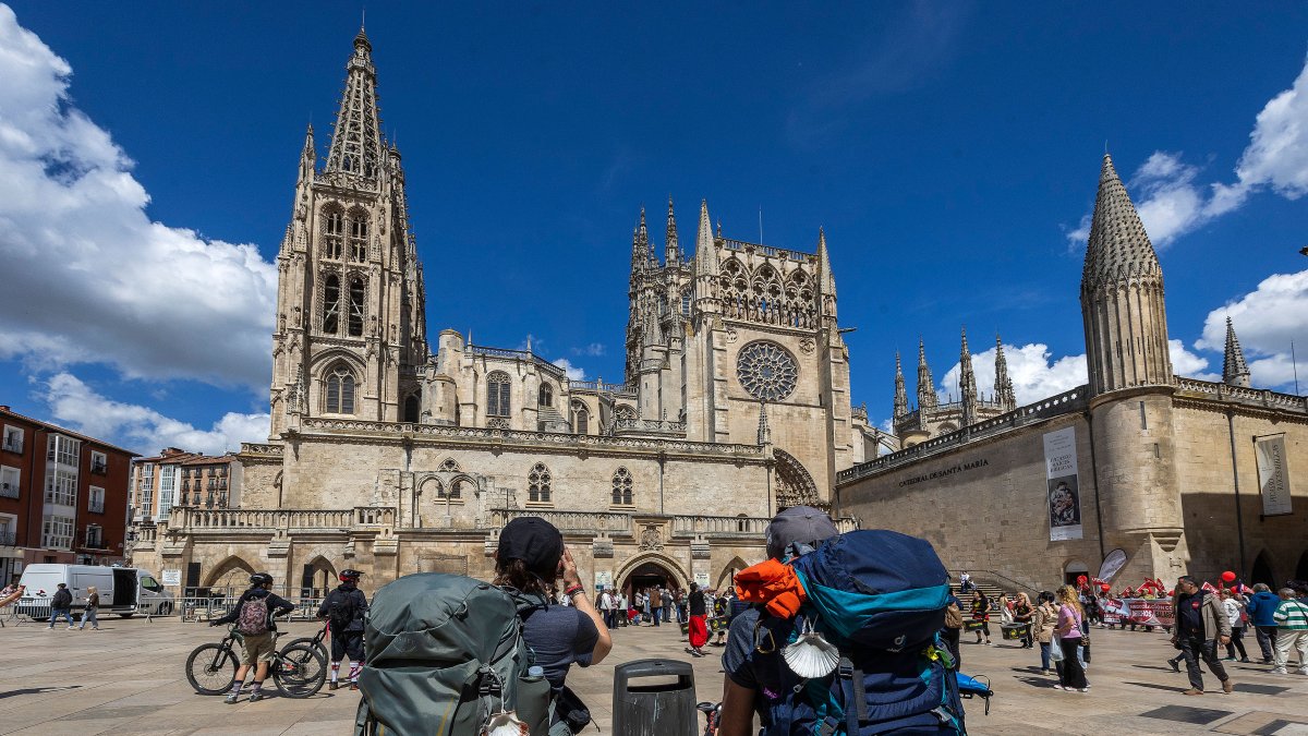 Unos peregrinos observan la Catedral de Burgos en la Plaza del Rey San Fernando.