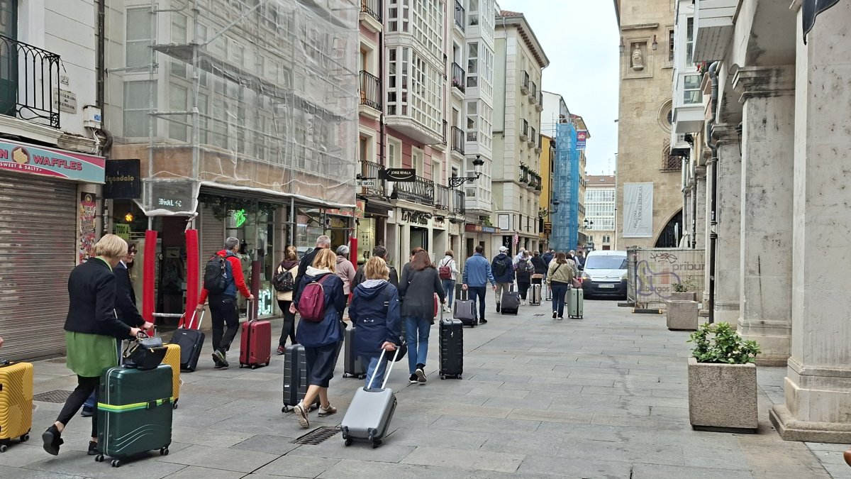 Un numeroso grupo de turistas caminando la semana pasada con sus maletas por la calle de La Paloma.