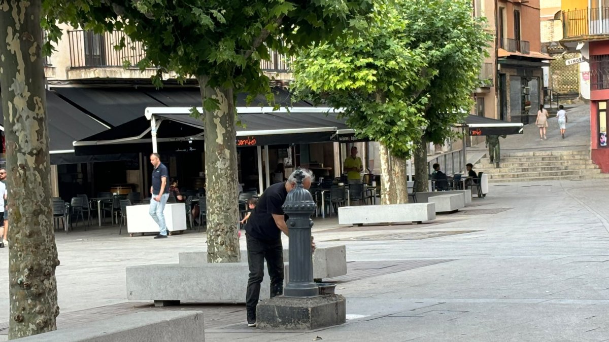 Un hombre bebe de la fuente en la plaza Mayor