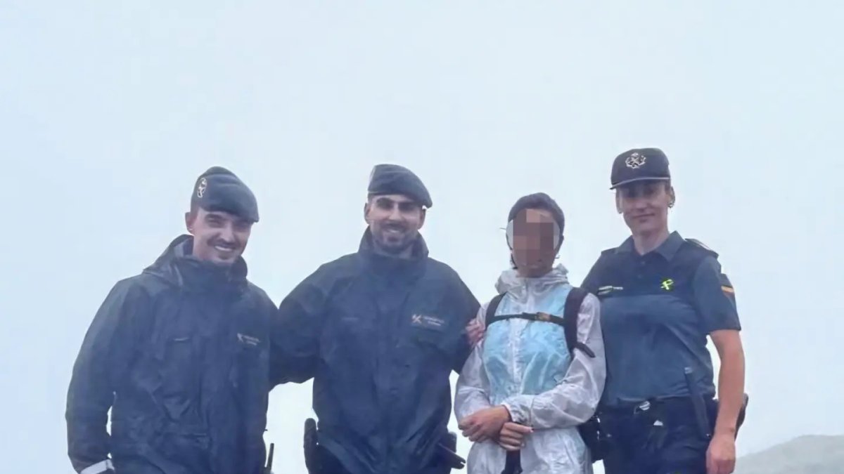 Los agentes con la senderista rescatada.