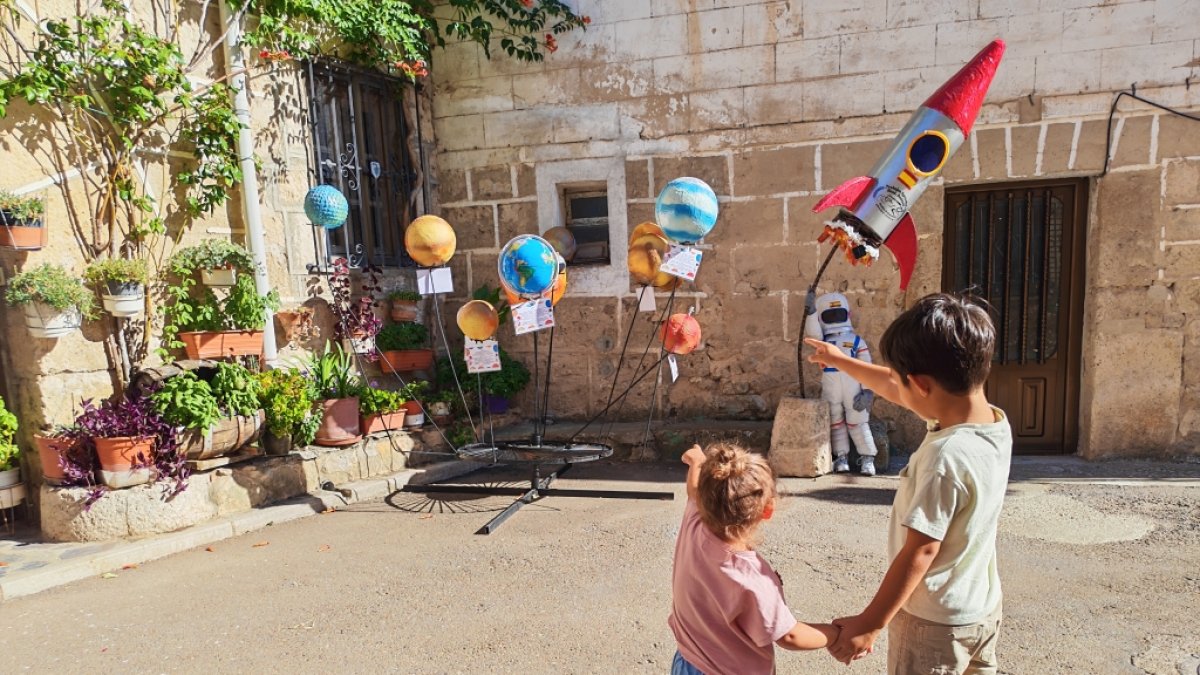 Dos niños miran una de las decoraciones de Olmillos de Sasamón.