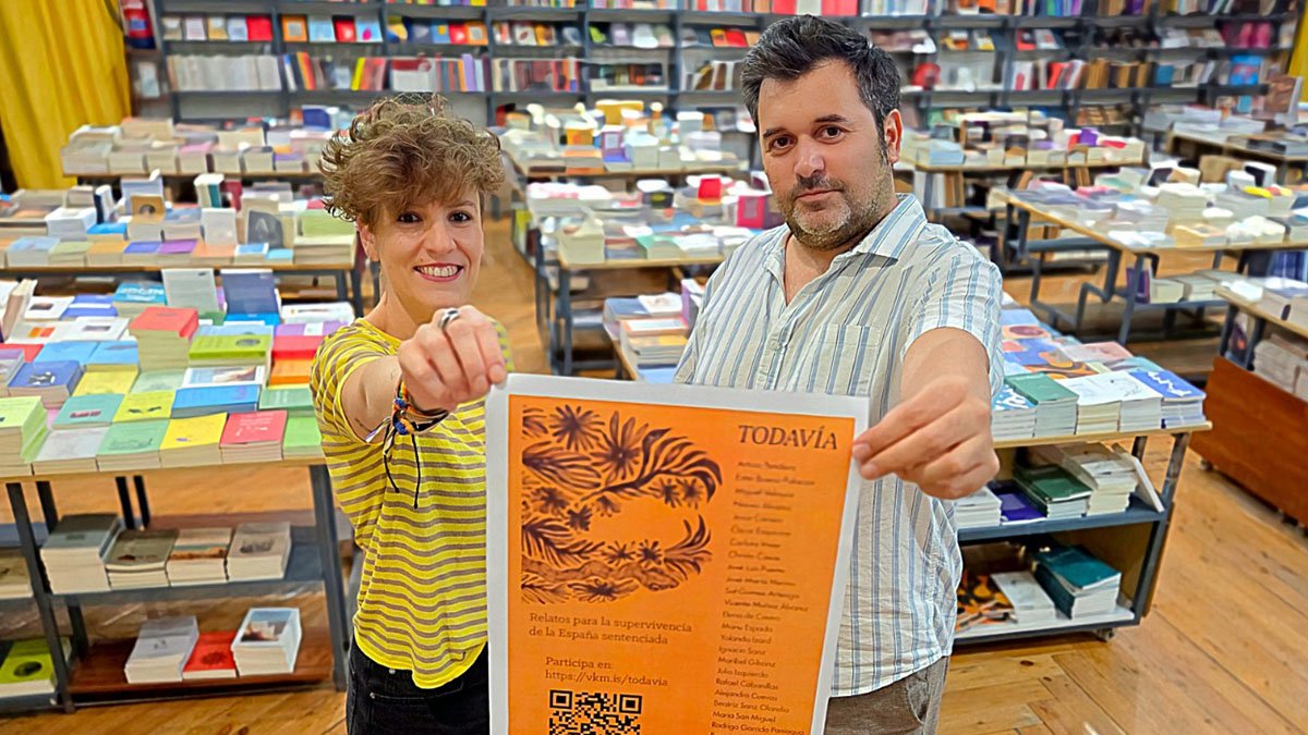 Los editores Virginia Hernández y Javier Campelo, con un cartel de 'Todavía'.