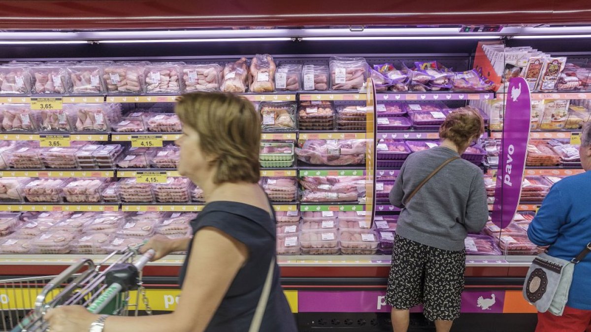 Varias mujeres en la sección de frescos envasados de un supermercado.