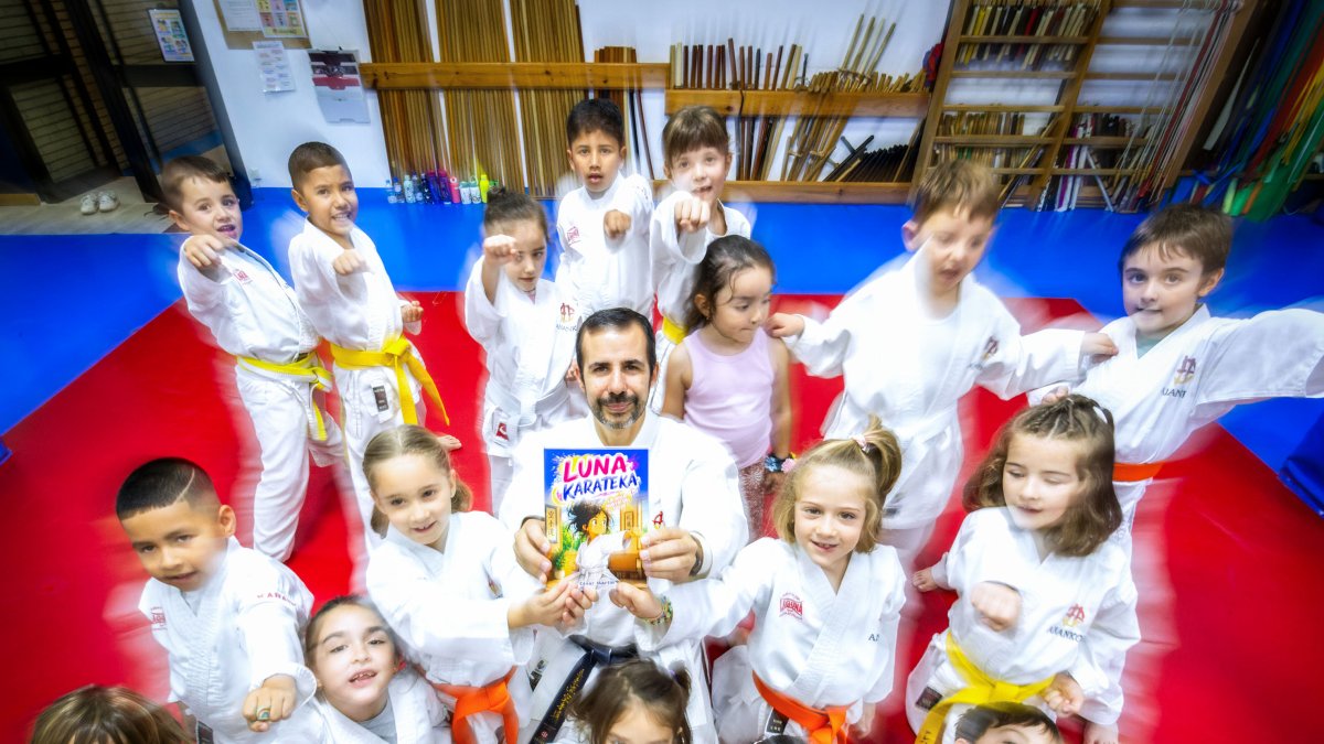 César Martín muestra su cuento rodeado de alumnos.